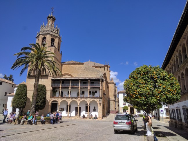 Templom, narancs fa, import pálma és megfáradt turisták. Spanyolország.